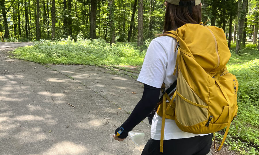 黄色いバックパックを背負い歩くスタッフ